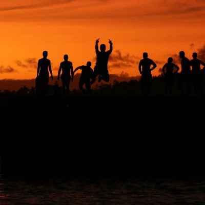 zwei wollen meer reiseblog segeln pazifik fiji weltreise lakeba lakemba sonnenuntergang jugendliche springen ins wasser silhouette